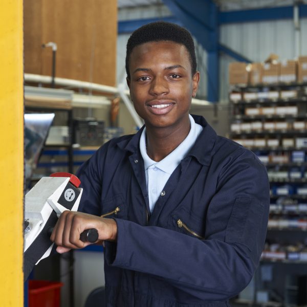 Factory Worker Using Powered Fork Lift To Load Goods